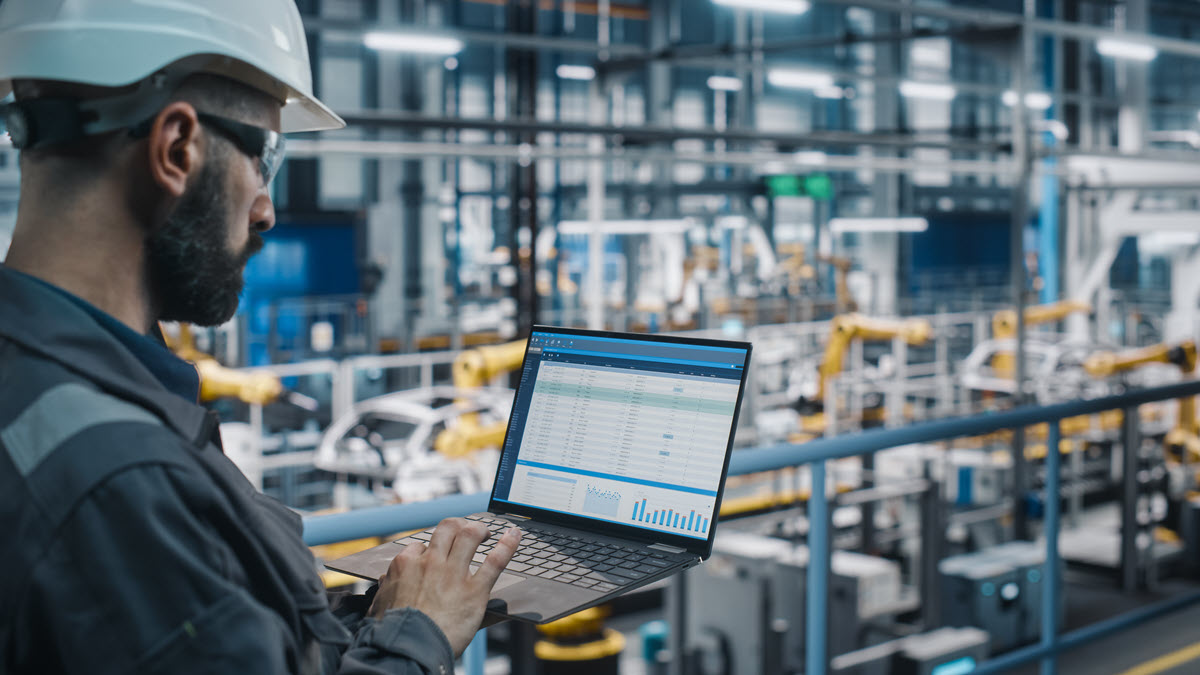 Worker in factory holding a laptop