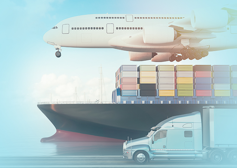 Plane flying over ship and a truck driving next to the ship.