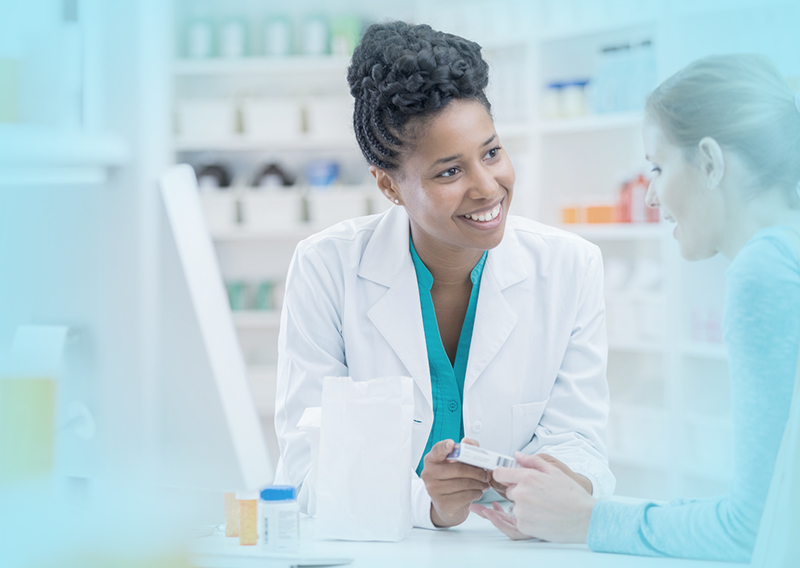Pharmacist and customer talking at counter.